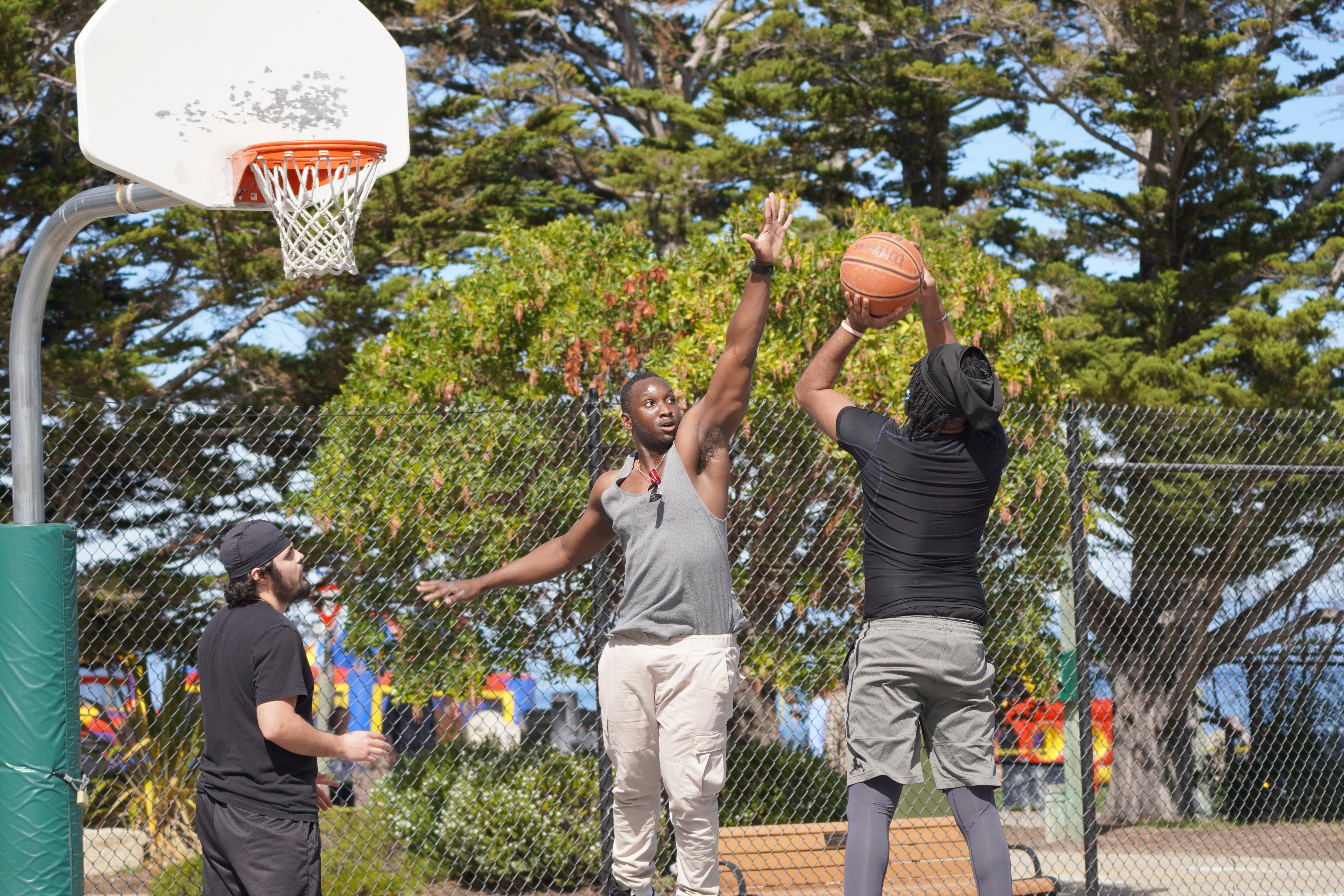 Outdoor action photo of people playing basketball on a court