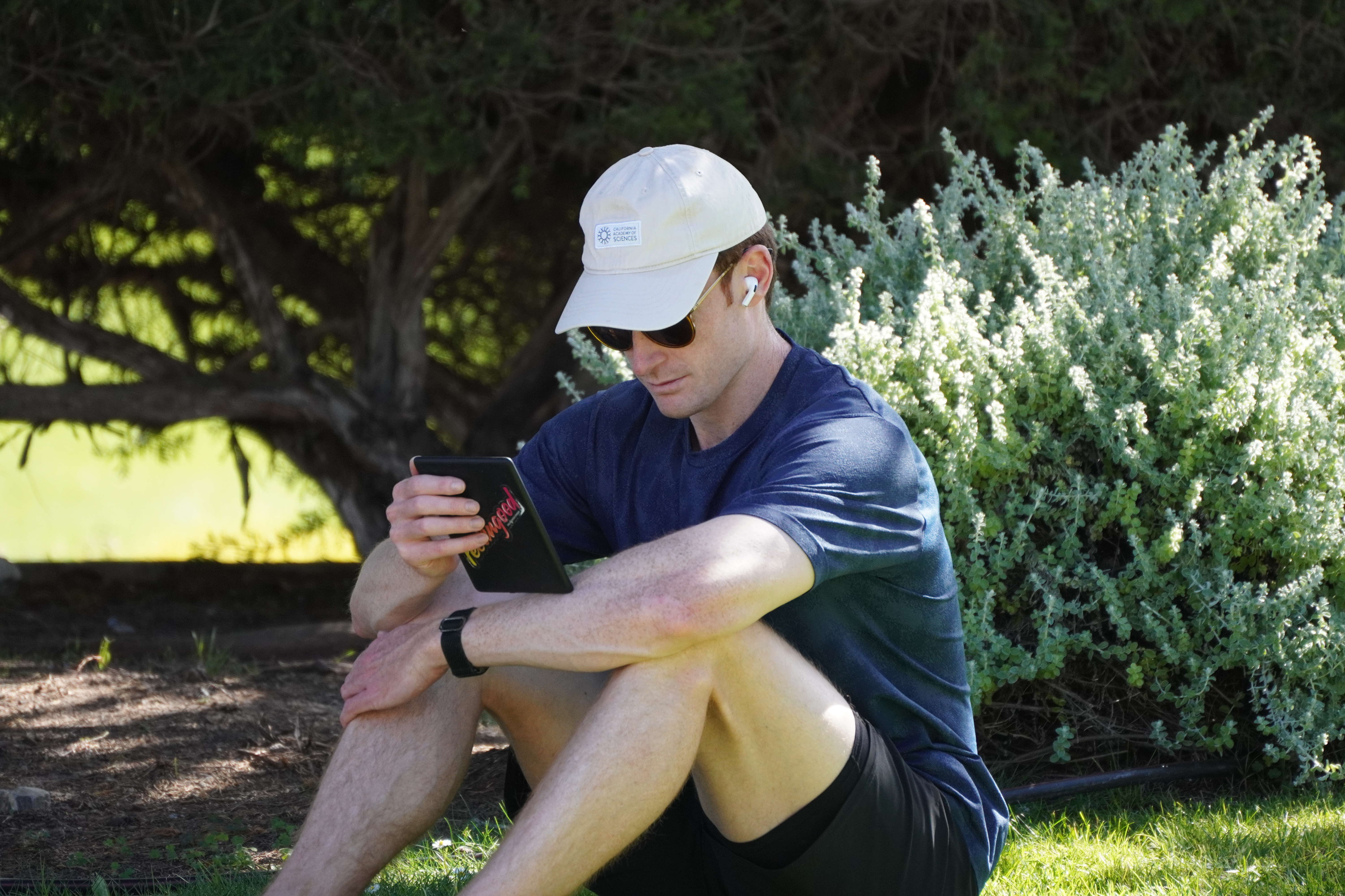 Portrait of a seated person outdoors looking at a handheld device