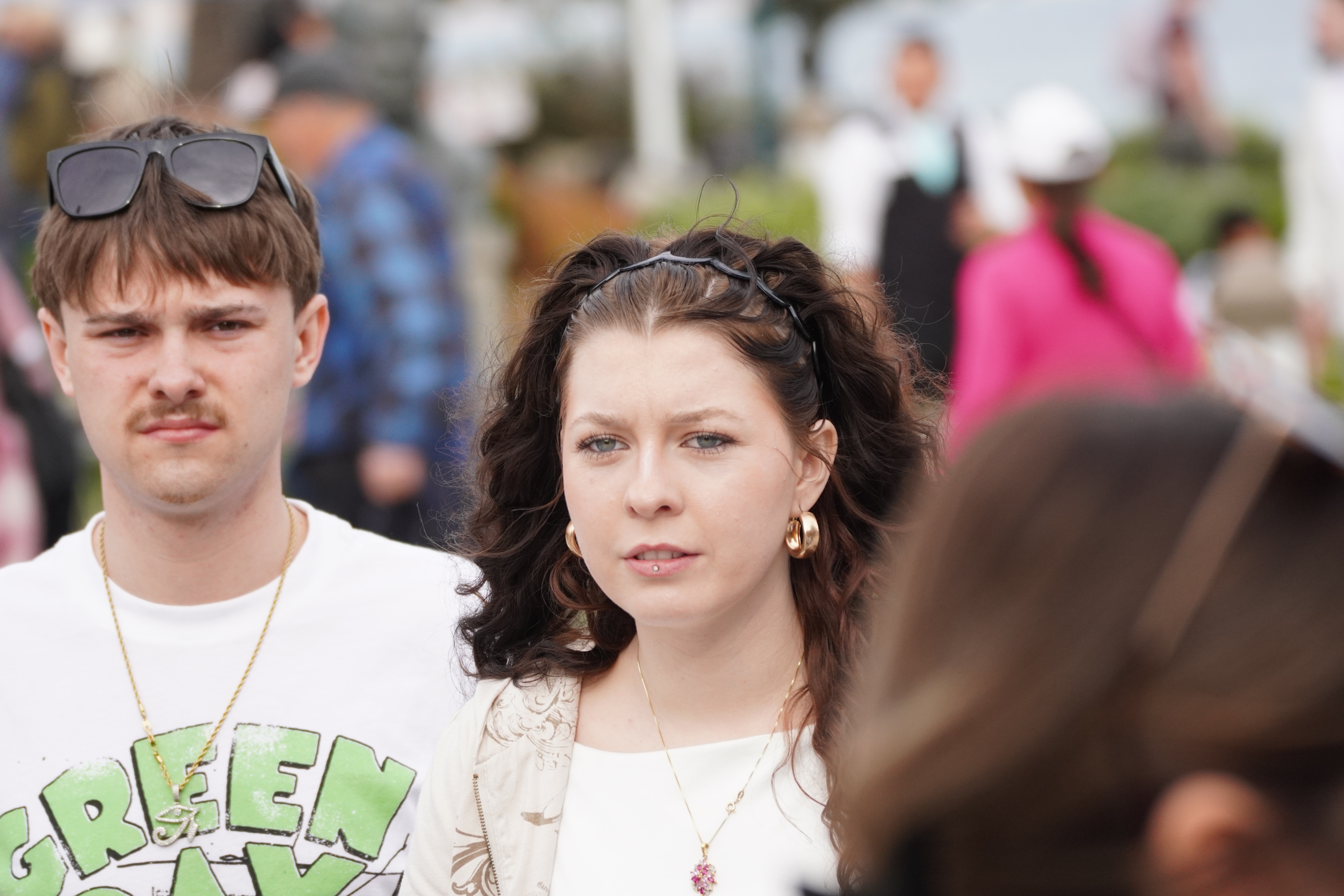 Street portrait of two people standing close together in a crowd